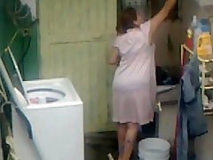Voyeur shot of a curvaceous mom in the laundry room